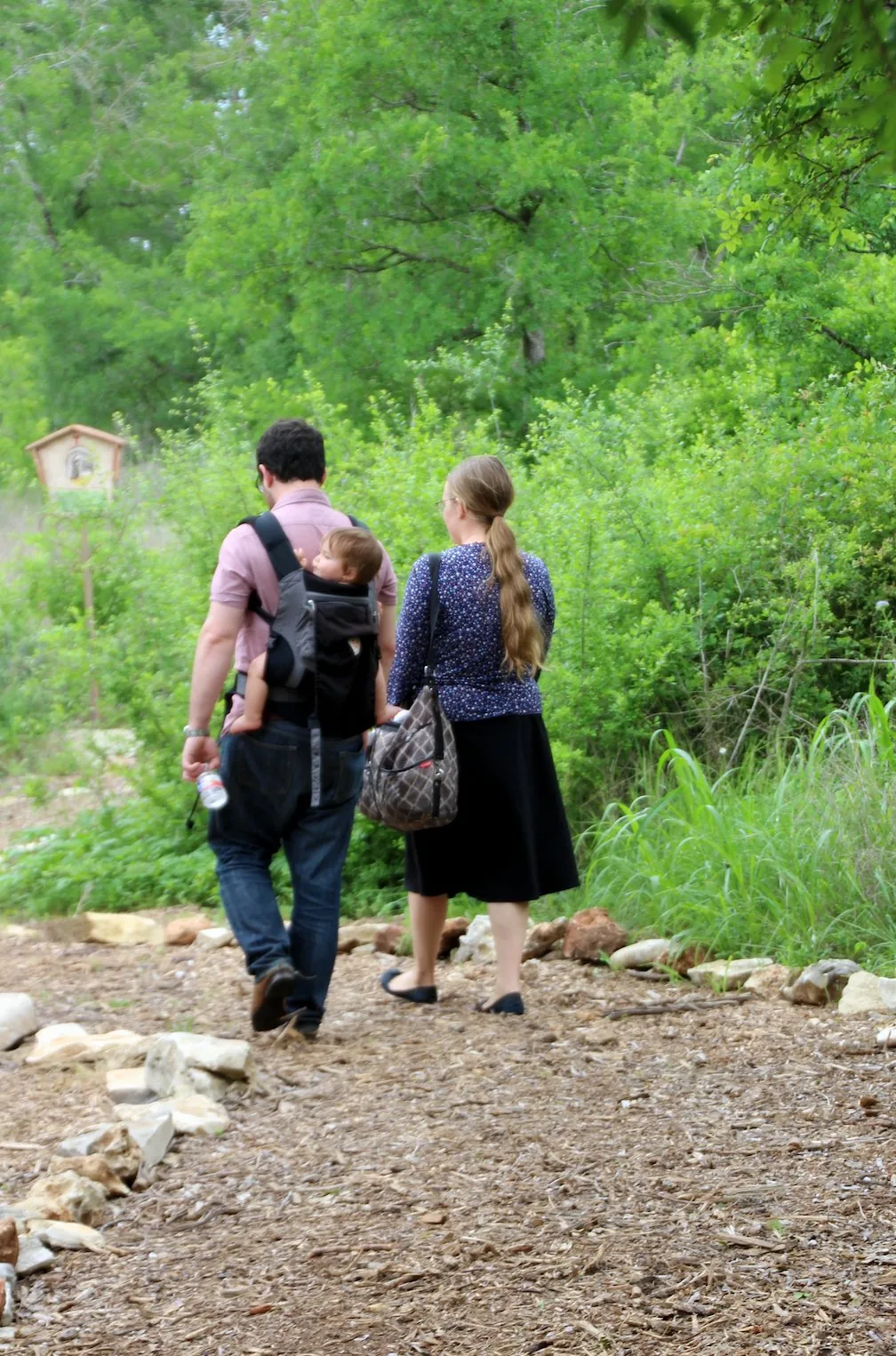 A family walking the St. Francis prayer path through the woods