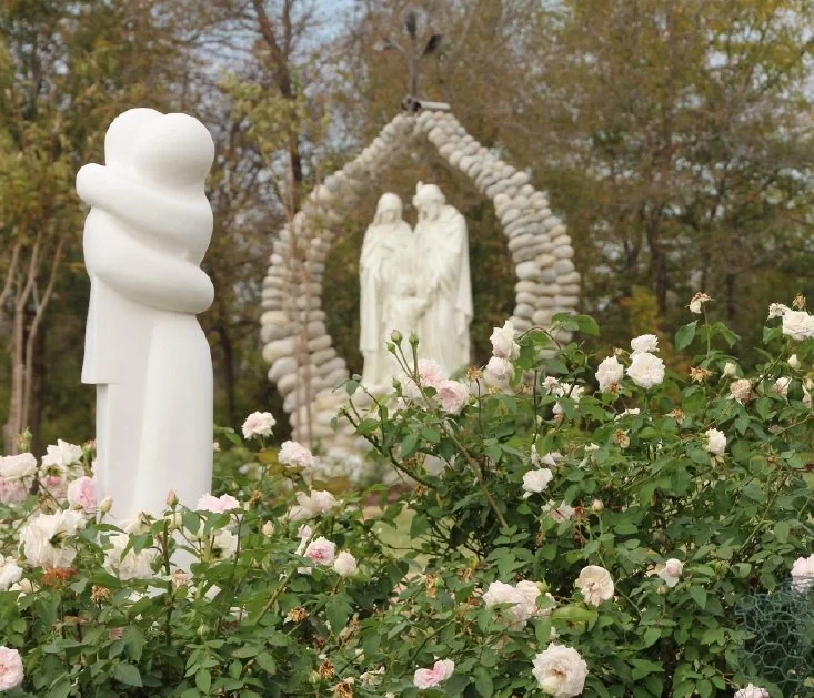 The Holy Family sculpture among roses at Our Lady of the Rosary Cemetery